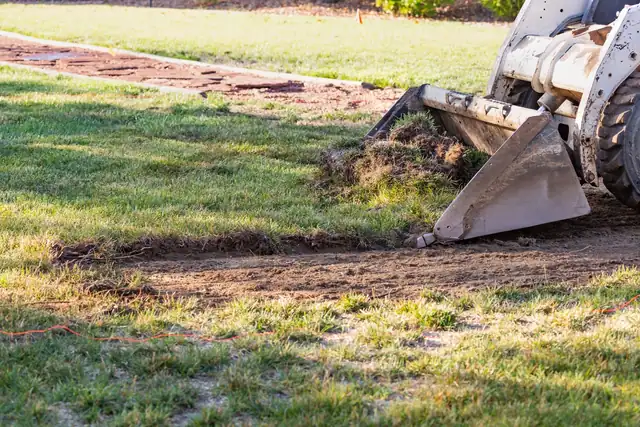 Compact track loader grading a site