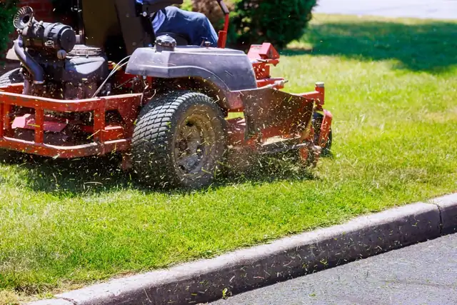 Lawn mower cutting a green lawn