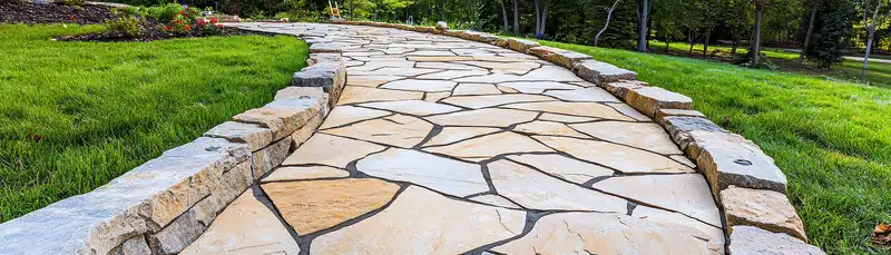 Winding natural stone pathway through a green lawn