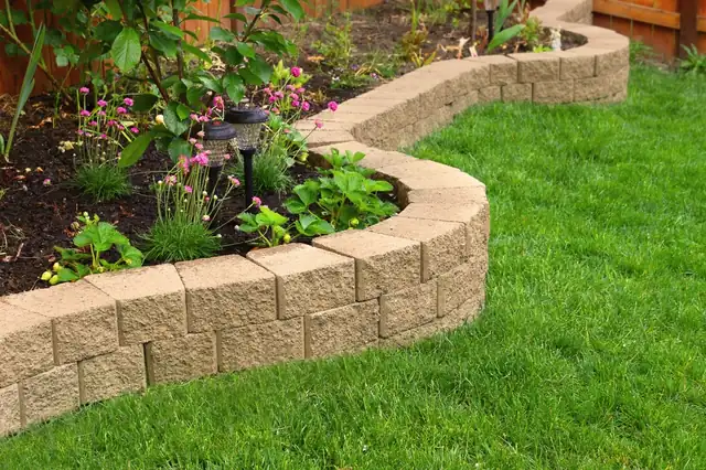 Block retaining wall beside a landscaped lawn